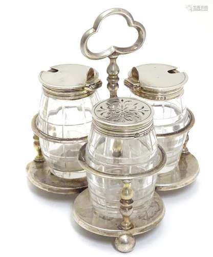 A Victorian silver cruet stand with three glass bottles of barrel form with silver mounts.