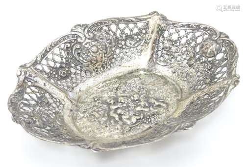 A Continental silver dish of basket form with lattice decoration and cast cherub scene. 7 1/4