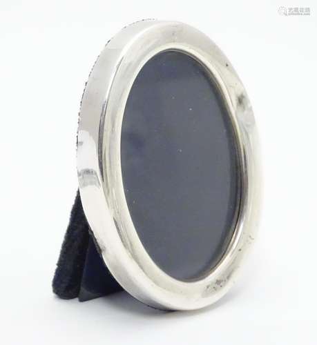 A photograph frame of oval form with silver surround hallmarked Sheffield 1927. Approx 3