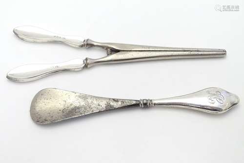 A silver handled shoe horn together with silver handled glove stretcher . the largest 7 1/2