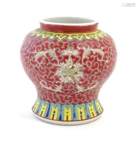 A Chinese famille rose squat vase with a flared base, the body with floral motifs and stylised bat