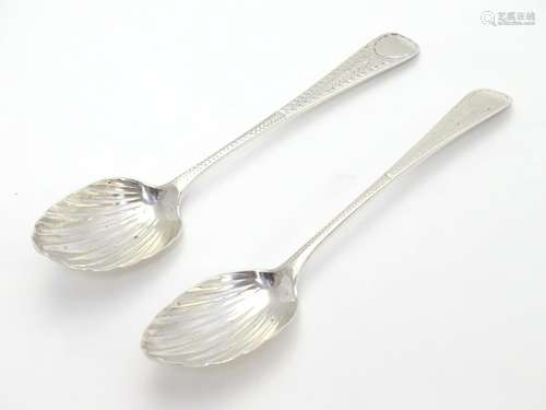 Two Geo III silver teaspoons with shell formed bowls and bright cut decoration to handles. one