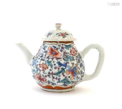 A Chinese teapot with scrolling floral and foliate detail. Approx. 4 1/2