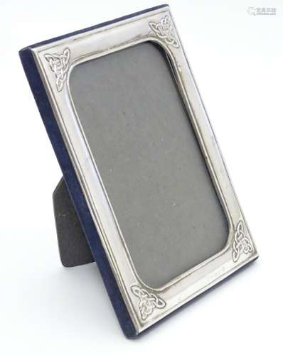 An Irish photograph frame with silver surround having Celtic-style designs at each corner.