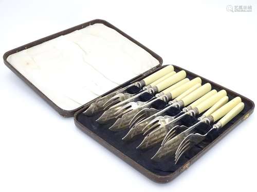 A cased set of fish knives and forks (6+6), each with silver collar hallmarked Sheffield 1926