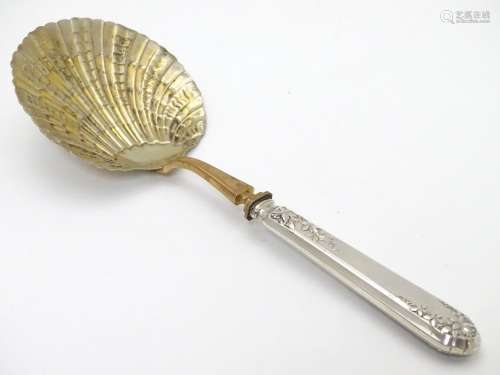 A French silver handled serving spoon with foliate decoration to the handle and a scallop formed