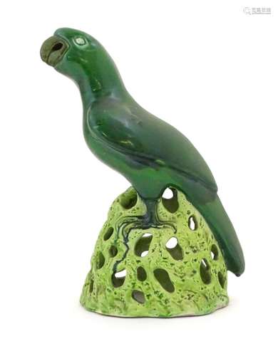 A Chinese model of a parrot with a green glazed on a pierced base. Approx. 12