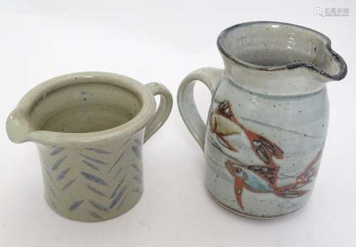 Two studio pottery jugs, one with stylised fish decoration, the other with brushwork chevron detail.