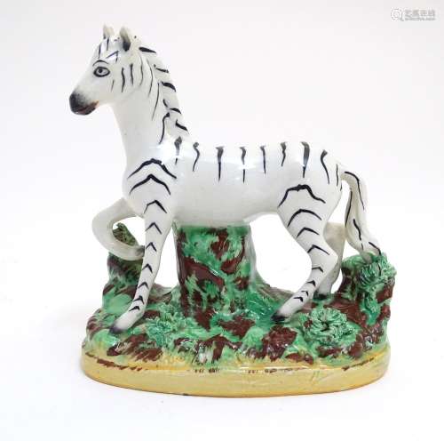 A Staffordshire figure modelled as a zebra on a naturalistic oval base. Approx. 4 3/4