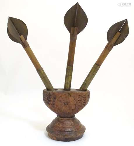 Three naive 20thC oversized darts with associated carved wooden base with chip carved detail.