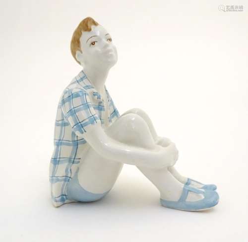 A Russian figure modelled as a seated boy / dreamer. Marked under. Approx. 4 1/2