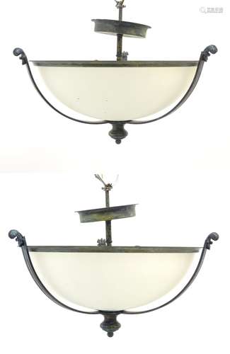 A pair of ceiling lights with frosted glass domed shades and metal strap work 18