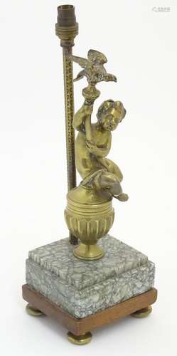 A 20thC table lamp decorated with cast figure of a putto holding aloft a bird, mounted upon a