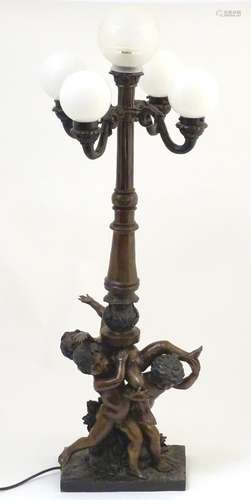 A 20thC bronze lamp with 5 glass globe shades. , the central column supported by putti. the whole