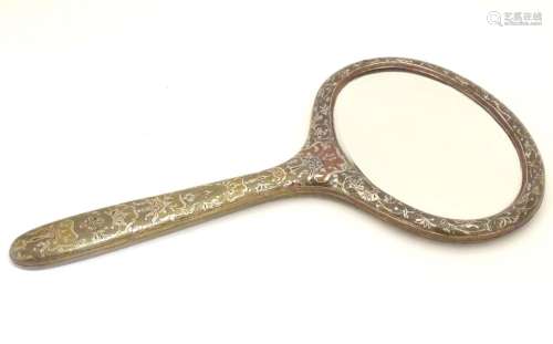 A late 19th / early 20thC hand mirror with Damascene style decorative surround and oval bevelled
