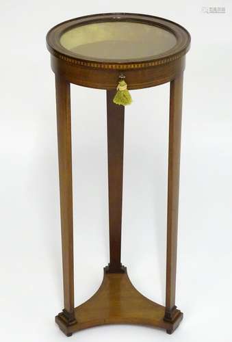 A 19thC bijouterie cabinet with a circular glass top above an inlaid checkered frame and having