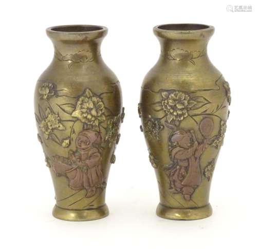 A pair of late 19th / early 20thC miniature brass vases with engraved and relief decoration