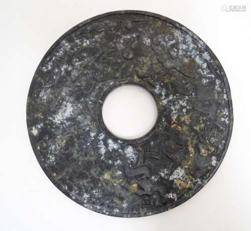 A large hardstone roundel with engraved detail depicting stylised animals, bears, tigers etc.