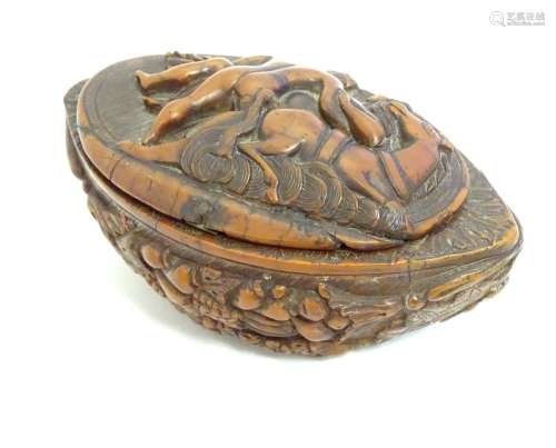 A Continental carved nut snuff box, the hinged lid decorated with a horse and a man carrying a
