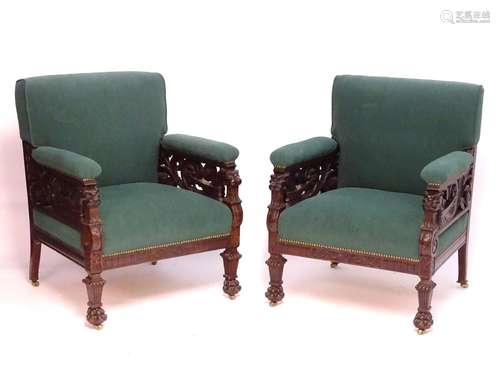 A pair of late 19thC mahogany armchairs with an upholstered backrest and seat, having lions masks