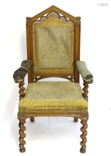 A mid / late 19thC oak armchair with a pointed pierced cresting rail, moulded frame and raised on