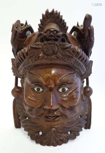 A 20thC Chinese carved hardwood mask with carved dragon detail and inset eyes. Approx. 10 1/4
