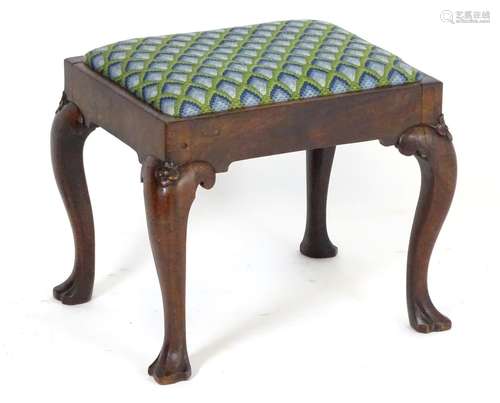 A George I mahogany cabriole leg stool of peg jointed construction, having a drop in seat above