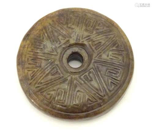 A Chinese carved hardstone roundel with incised geometric detail. Approx. 2
