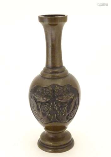 An Oriental bronze vase of baluster form with a stepped base and neck, the body with cast