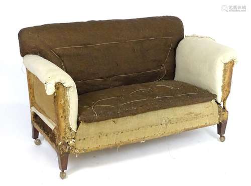 An early 20thC drop end sofa for re upholstery, raised on squared tapering leg and terminating in