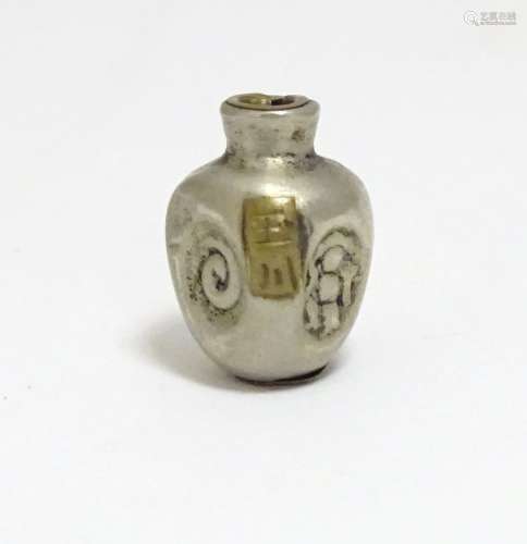 A Japanese silver plate ojime bead formed as a stylised vase with impressed detail and applied brass