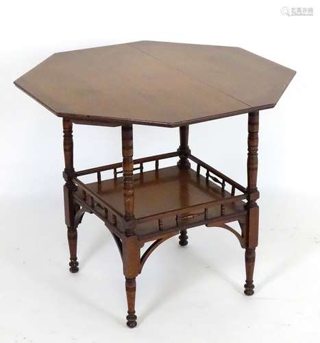 An Aesthetic movement walnut table with an octagonal top above a galleried under tier with corner