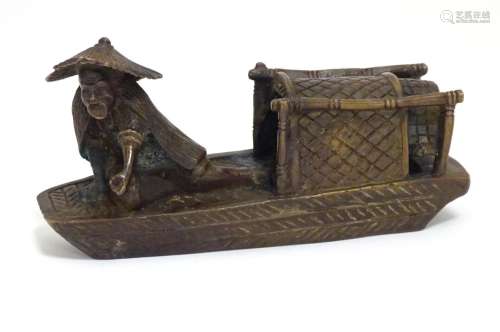 An Oriental bronze model of a fishing boat with a figure fishing. Approx. 6 1/2