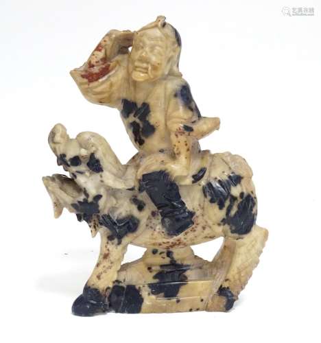 A Chinese soapstone model of a figure riding a Qilin style creature. Approx. 5 1/2