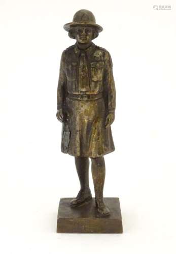 A 20thC cast bronze model of a Girl Guide wearing a hat and uniform, on a square base. Approx. 6