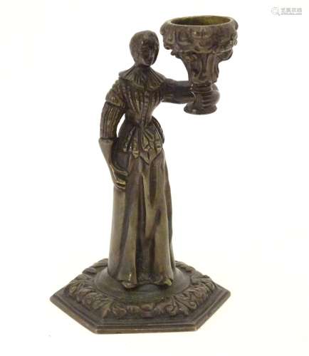 A 19thC cast bronze figure of a woman holding a vase aloft on a hexagonal base with foliate