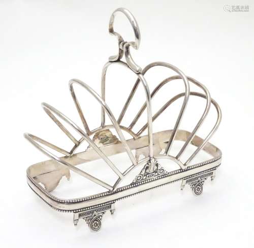 A silver plate 7 bar toast / letter rack with loop handle. Indistinctly marked with registration