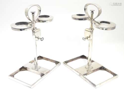 A pair of silver decanter stands / tantalus with locking mechanism to central column. Maker