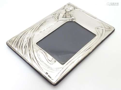 A photograph frame with silver surround with Art Nouveau style decoration. Hallmarked Birmingham