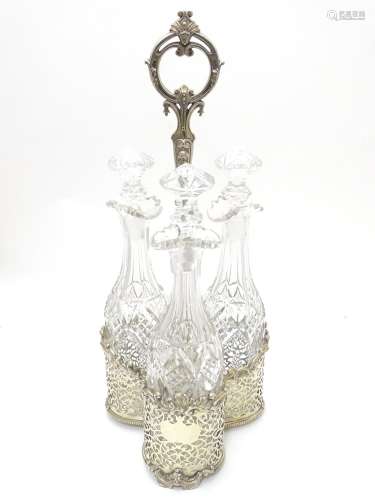 A Victorian silver plate tantalus / bottle stand with three cut glass decanters. The whole approx