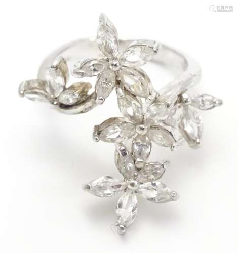 A silver dress ring with white stone decoration. Ring size approx O Please Note - we do not make
