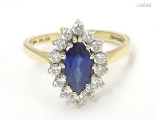 A 14k gold ring set with central sapphire bordered by white stones. Ring size approx N 1/2 Please