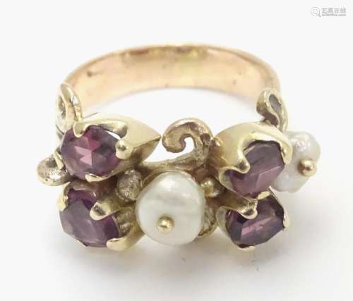 A 9ct gold ring dress ring set with 4 amethysts and two pearls. Hallmarked to outer band London 1976