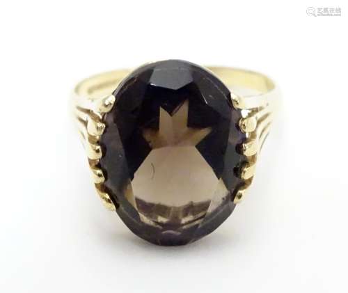 A 9ct gold ring set with central oval smoky quartz in a claw setting. Ring size approx M Please Note