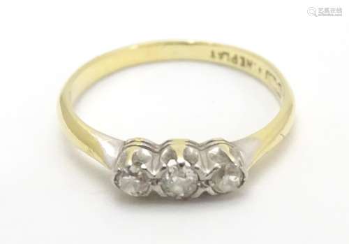 An 18ct gold ring set with trio of diamonds. Ring size approx M Please Note - we do not make