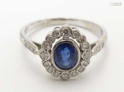 An 18ct white gold ring set with central sapphire bordered by diamonds Please Note - we do not