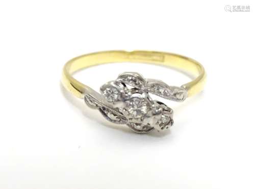 An 18ct gold ring set with trio of platinum set diamonds to top. Ring size approx M 1/2 Please