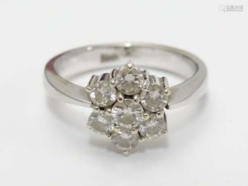 An 18ct gold ring set with 7 diamonds in a daisy cluster setting. the setting approx 3/8