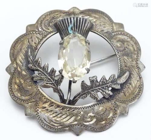 A Victorian Scottish silver brooch with engraved decoration and central thistle motif Hallmarked