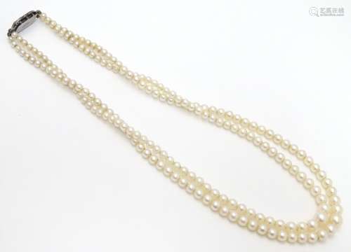 A double strand pearl necklace / choker of graduated pearls with silver and marcasite clasp.